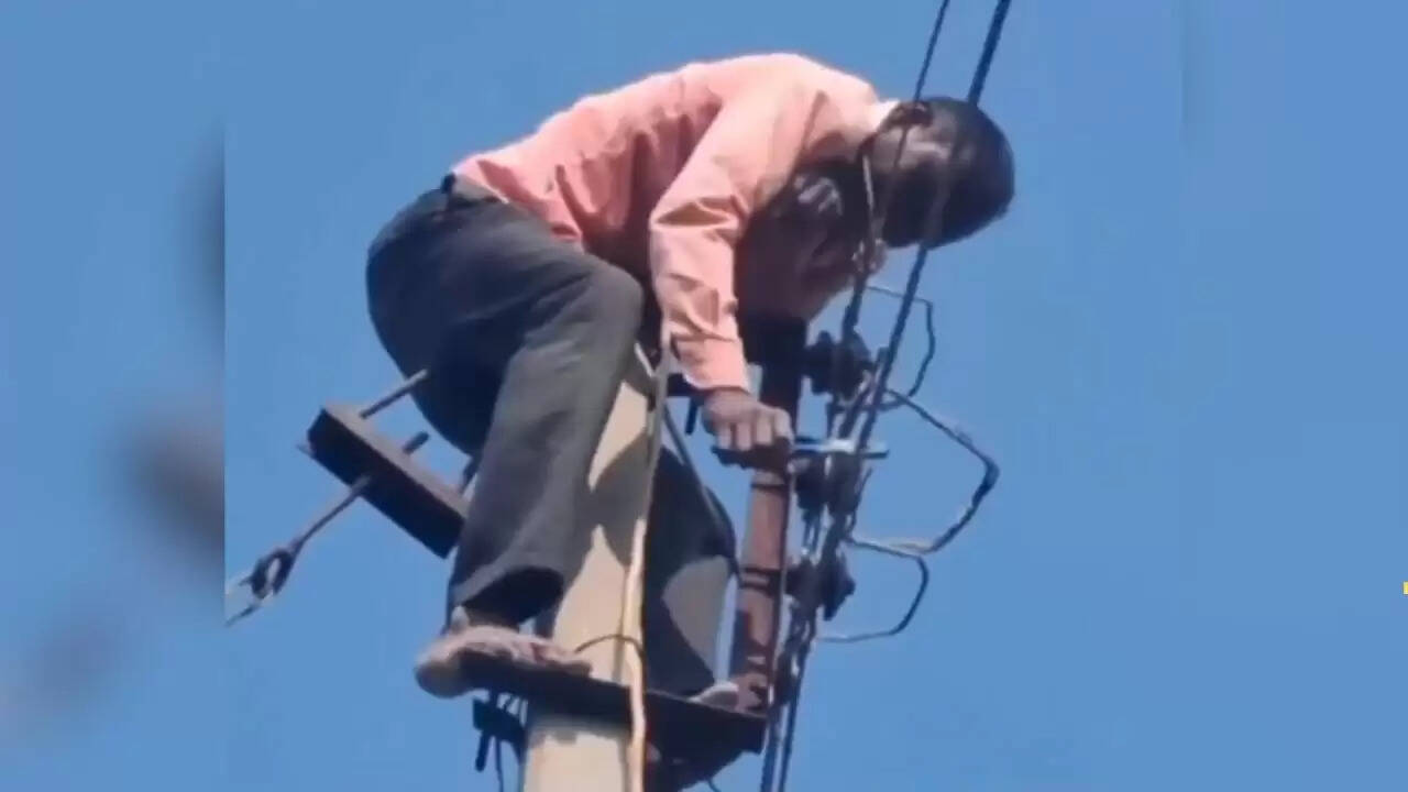 खतरनाक काम में जुटा शख्स: बिजली के पोल पर चढ़कर परिवार के लिए संघर्ष
